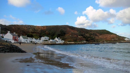A view of the beach with the houses behind and the cliffs beyond at Porthdinllaen, Gwynedd, Wales